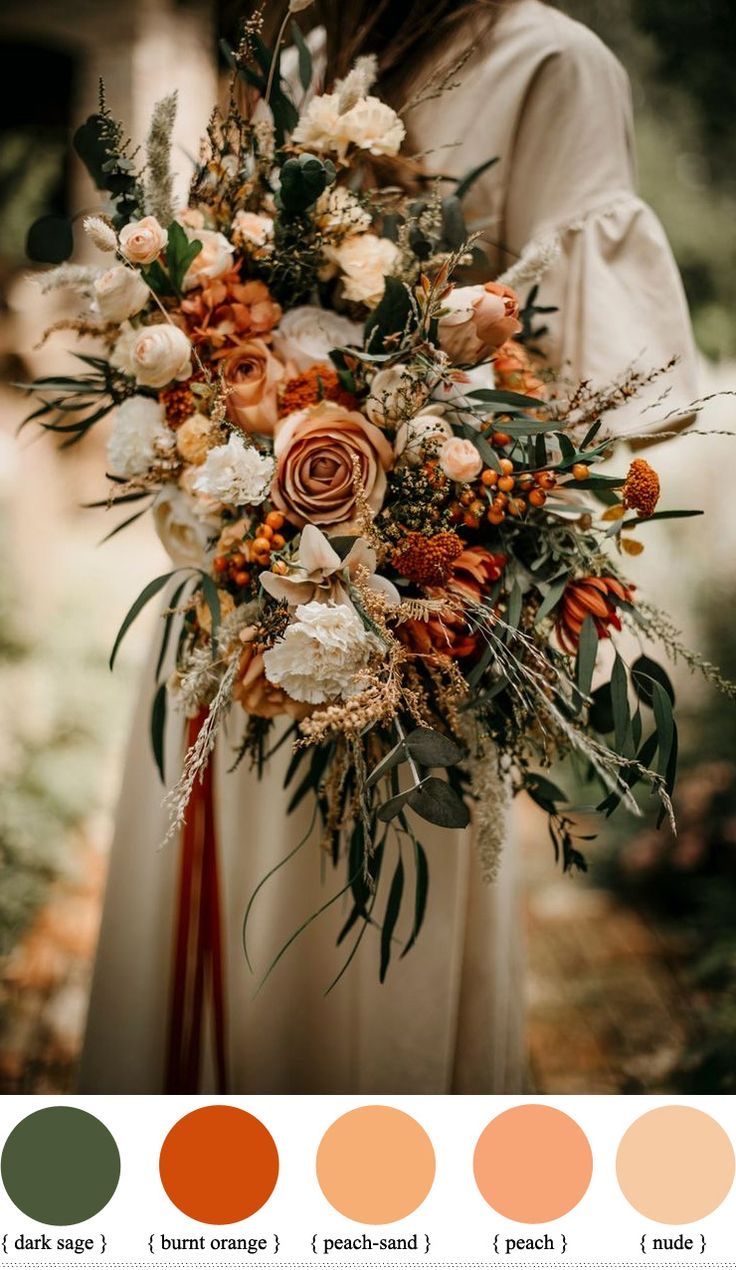 a woman holding a bouquet with oranges, browns and white flowers in her hands