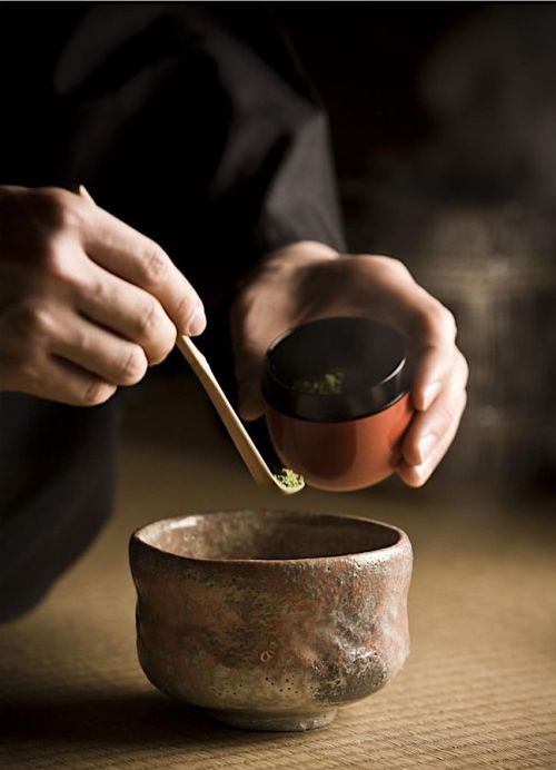 a person holding a spoon over a bowl