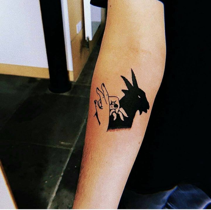 a tattoo on the arm of a person with a rabbit and chinese characters behind it