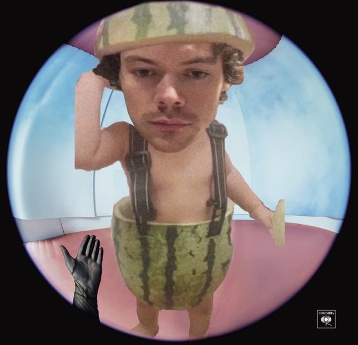 a man with a watermelon hat and overalls in front of a mirror