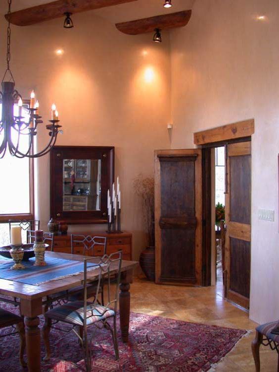 a dining room table with chairs and a chandelier hanging from it's ceiling