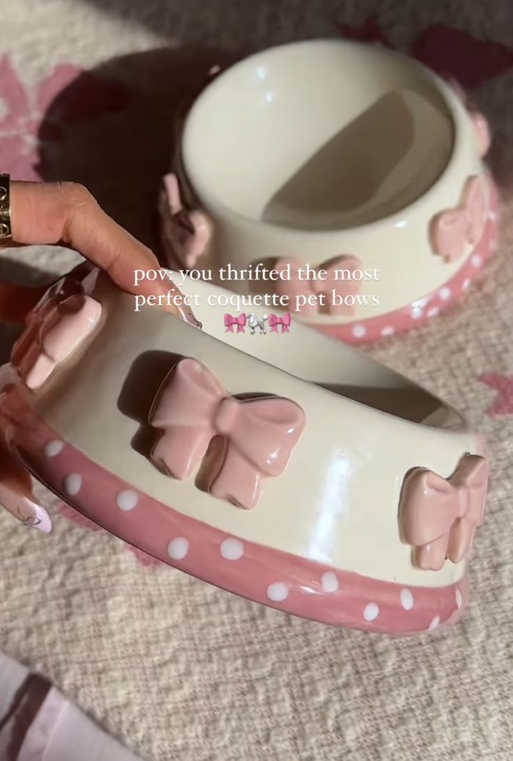 a woman is holding her pink and white cat shoe with polka dots on the bottom