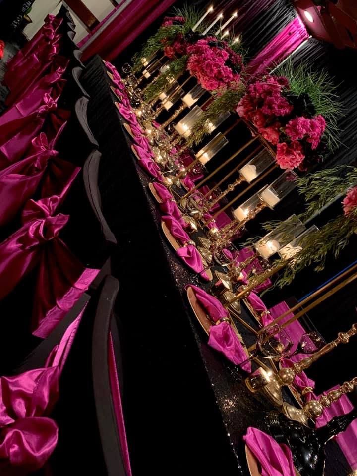 the table is covered with pink flowers and candles