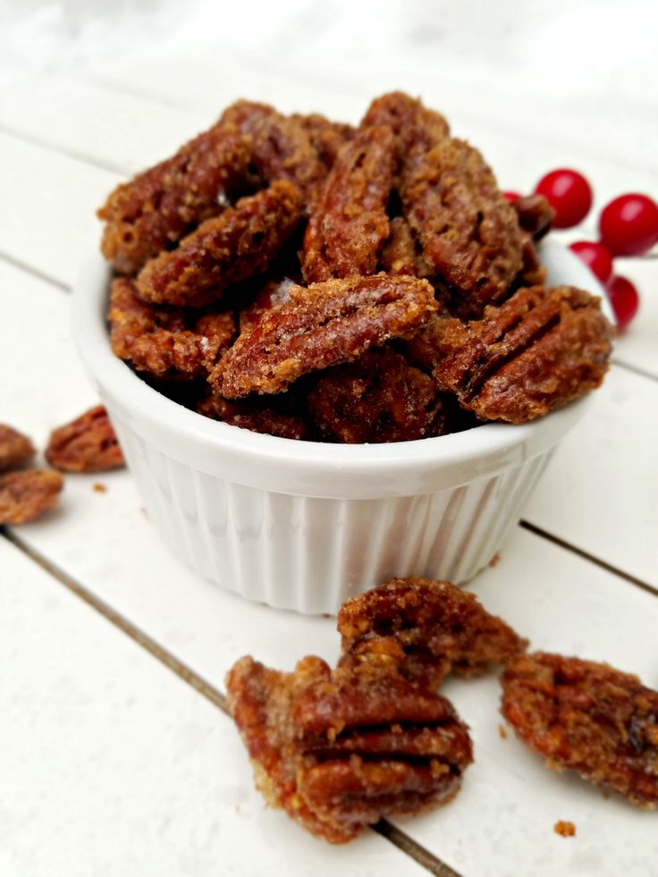 a white bowl filled with pecans sitting on top of a table