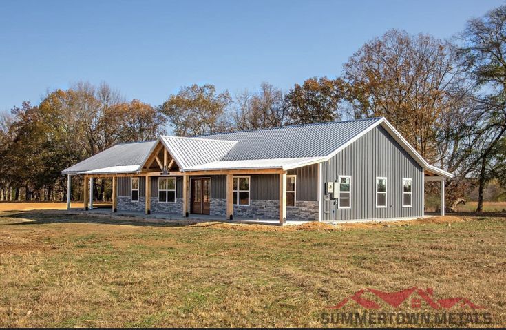 this is an image of a house in the middle of a field with grass and trees