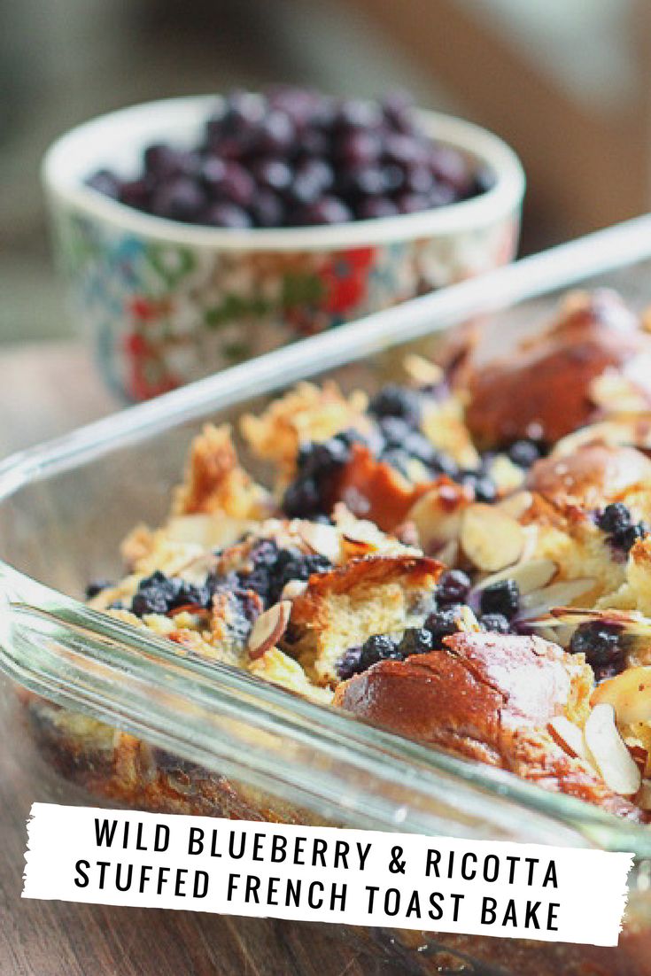 blueberry and ricotta stuffed french toast bake in a glass dish with the words wild blueberry and ricotta stuffed french toast bake