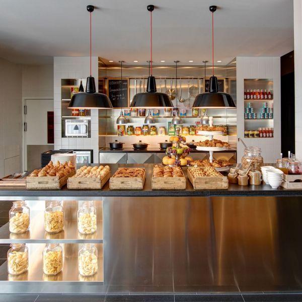 a counter with lots of food on it and hanging lights above the counter in front of it