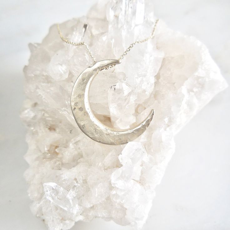 "This unique crescent moon phase pendant is available in silver or 14 k gold. So beautiful polished but equally stunning hand-finished matte, hammered or have it encrusted with diamonds. A focal piece that can be stacked with smaller pendants. It's a slide providing space for a pendant to fit into the opening. We've paired it with our bezel set moonstone. crescent moon 24 millimeters long x 19 mm wide or/ almost 1\" long x 3/4\" wide 14k solid gold or sterling silver pave Diamond encrusted Cresc Celestial Crescent Engraved Jewelry, Celestial Half Moon Jewelry For Anniversary, Celestial Moon Phase White Gold Jewelry, Celestial White Gold Moon Phase Jewelry, Artisan Silver Jewelry With Moon Charm, Celestial Crescent Jewelry In White Gold, Artisan Necklace With Moon Charm, Celestial Crescent White Gold Jewelry, Artisan Silver Jewelry With Moon Phase