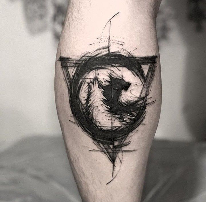 a black and white photo of a person's leg with a wolf tattoo on it