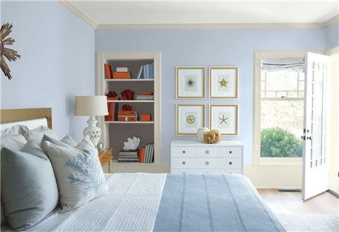 a bedroom with purple walls, white furniture and pictures on the wall above the bed