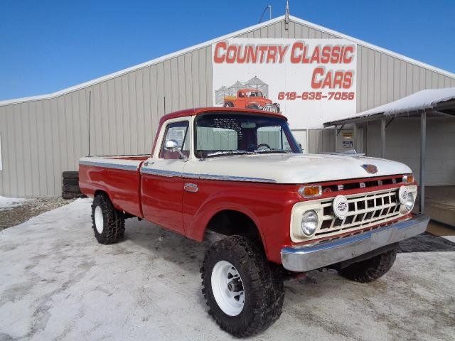 a red and white truck parked in front of a country classic cars building with snow on the ground