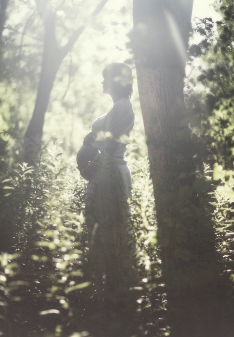 a woman standing in the middle of a forest