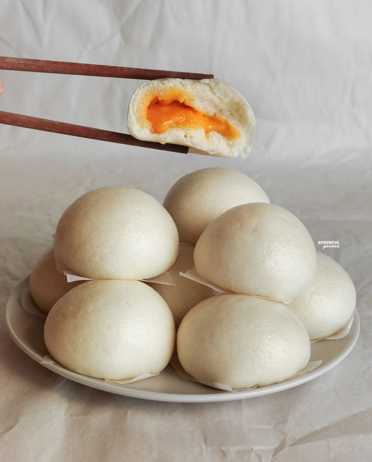 a plate full of food with chopsticks sticking out of the top and an egg in the middle