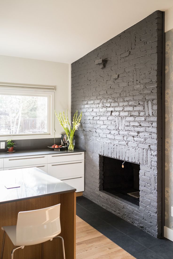 a kitchen area with a fireplace, counter top and chairs in front of the stove