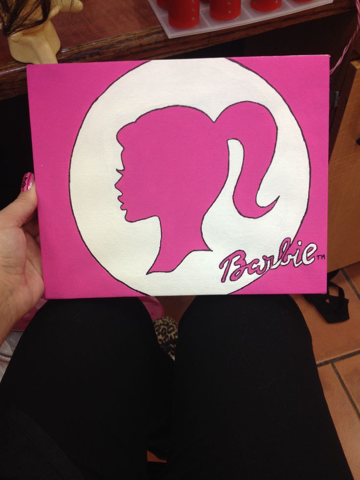 a person holding up a pink and white sign with the word barbie on it's face