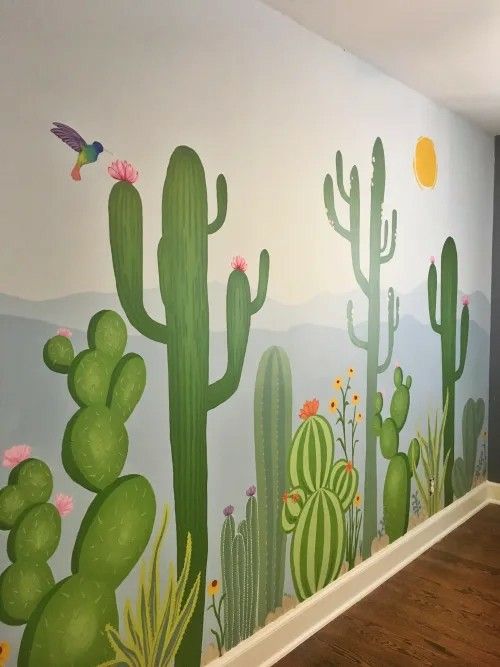 a wall painted with cactus and birds on it