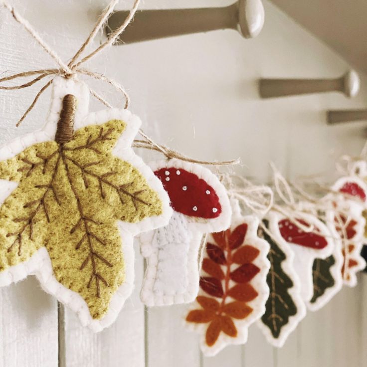 an assortment of leaf ornaments hanging from a hook