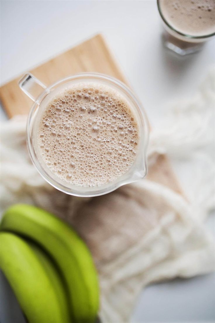 there is a banana next to a glass of milk