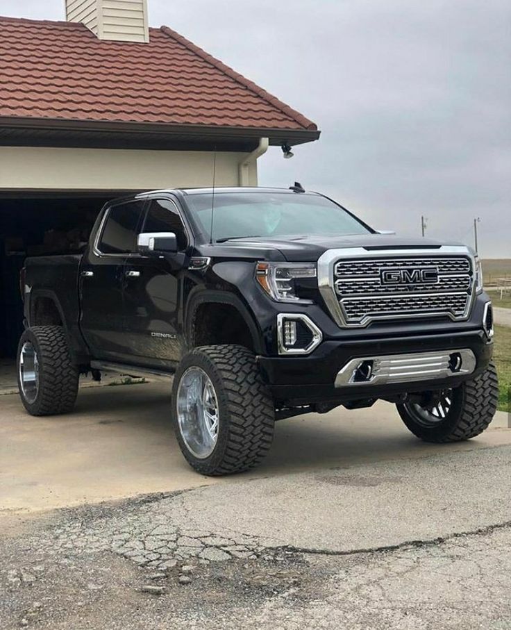 a black truck parked in front of a garage