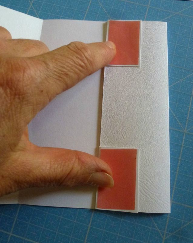 a hand is pressing the corner of a piece of paper