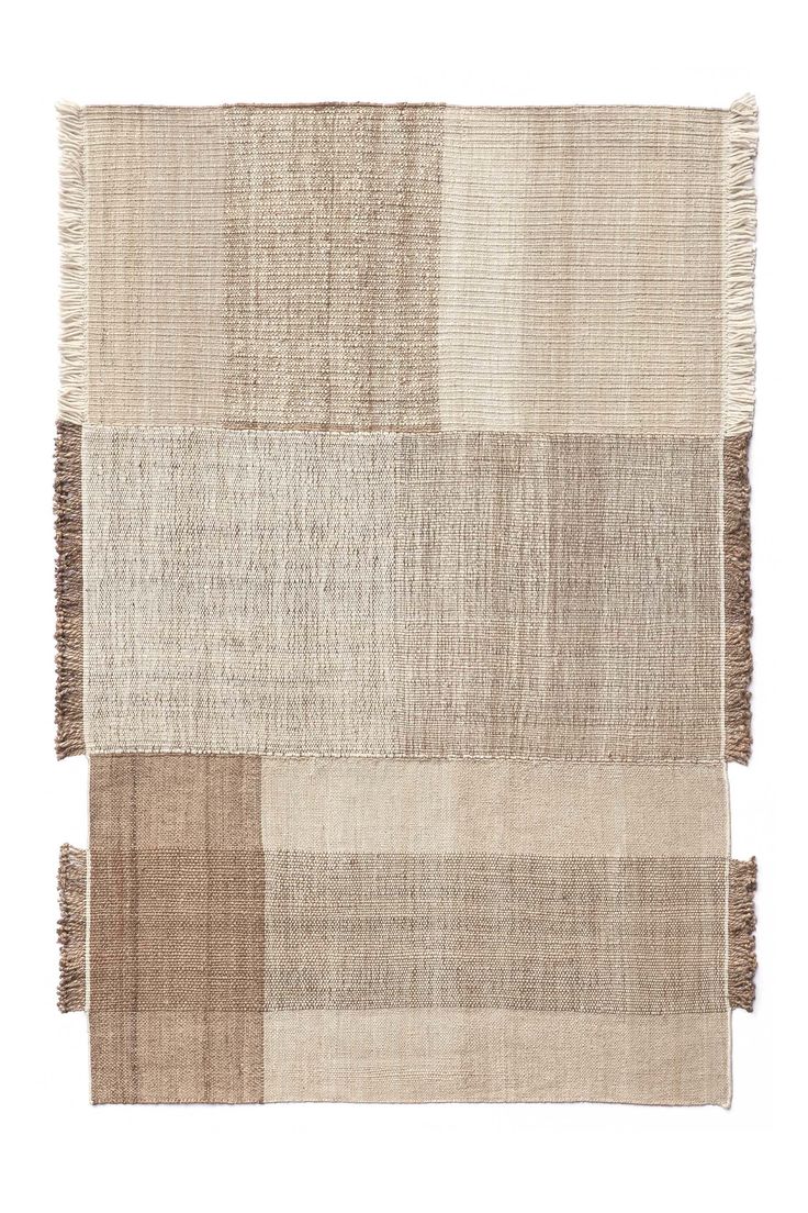 a beige rug with fringes on the top and bottom, in different shades of brown