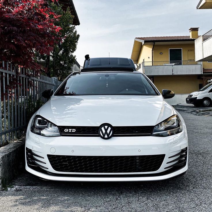 a white car parked in front of a house