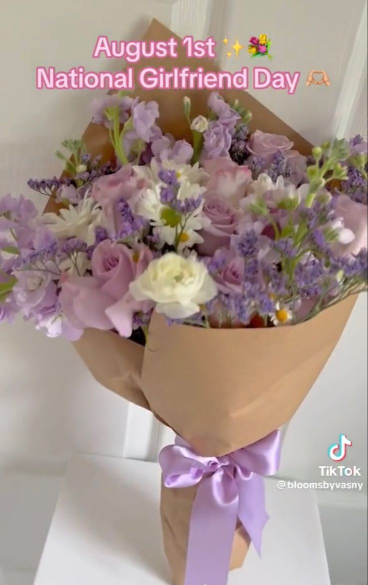 a bouquet of flowers sitting on top of a white table next to a sign that says national girlfriend day