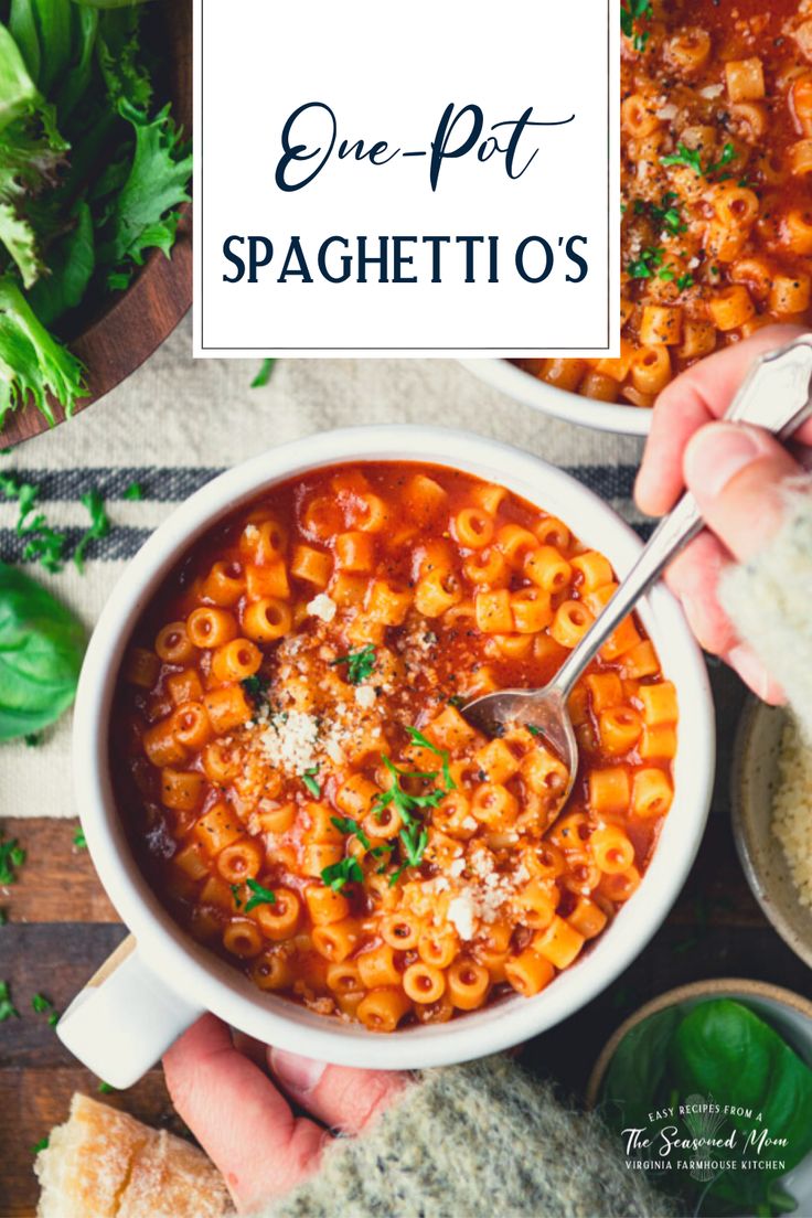 two hands holding a spoon over a bowl of pasta