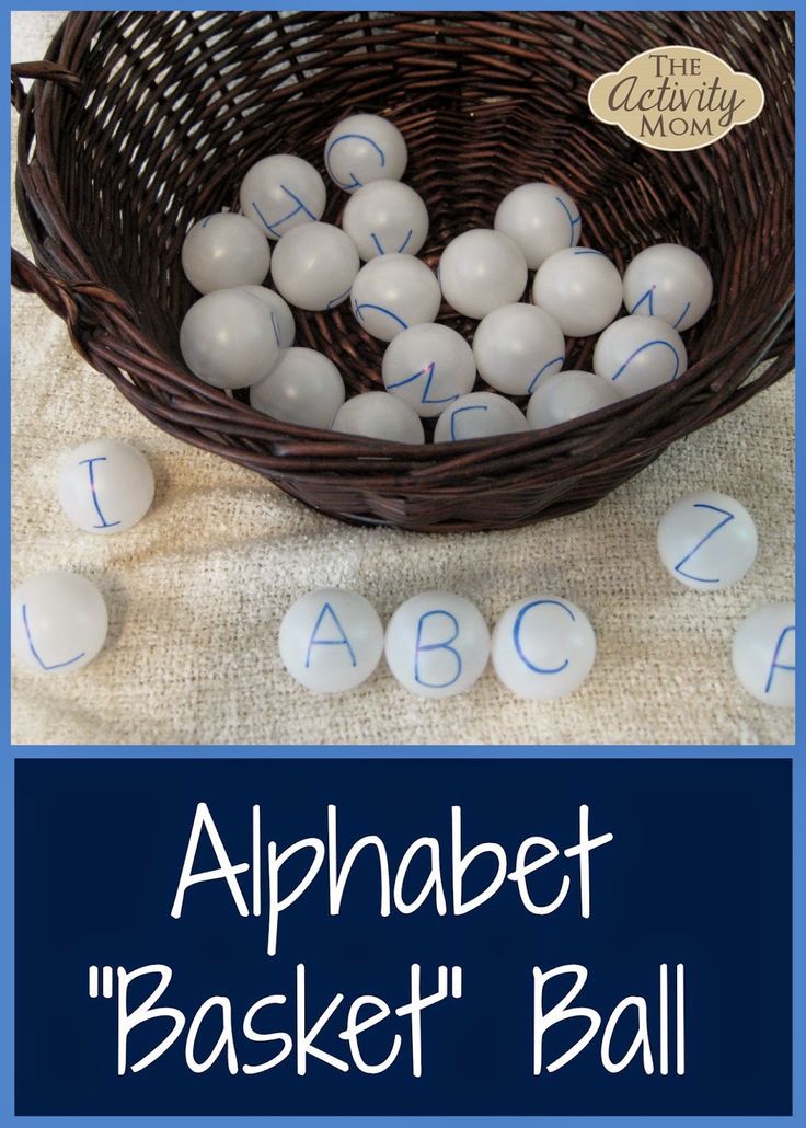 a basket filled with white plastic balls next to the words alphabet and numbers on it