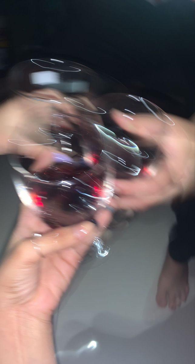 several people are holding wine glasses in their hands and reaching for the glass to be filled with them