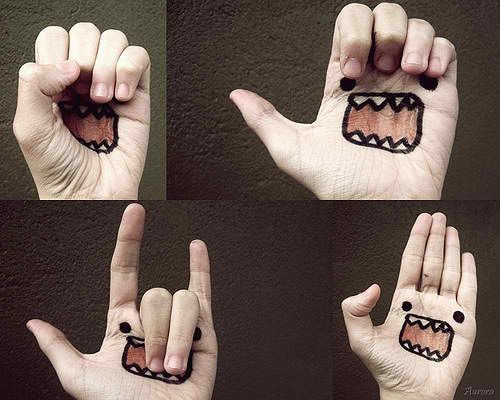 four pictures of hands with different designs on their fingers and one has a face drawn on it