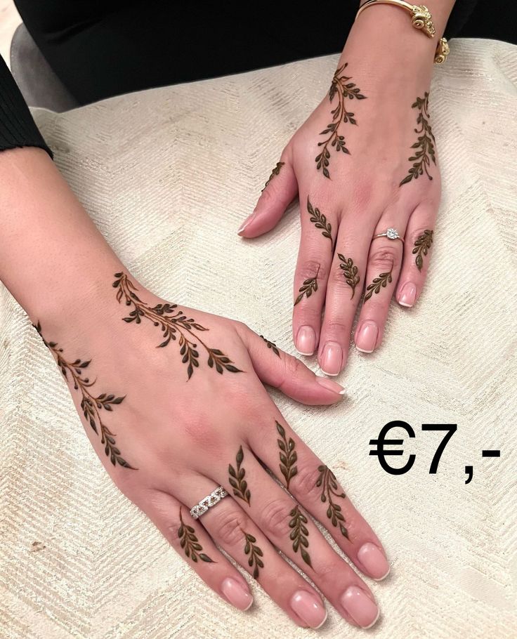 two hands with henna designs on them