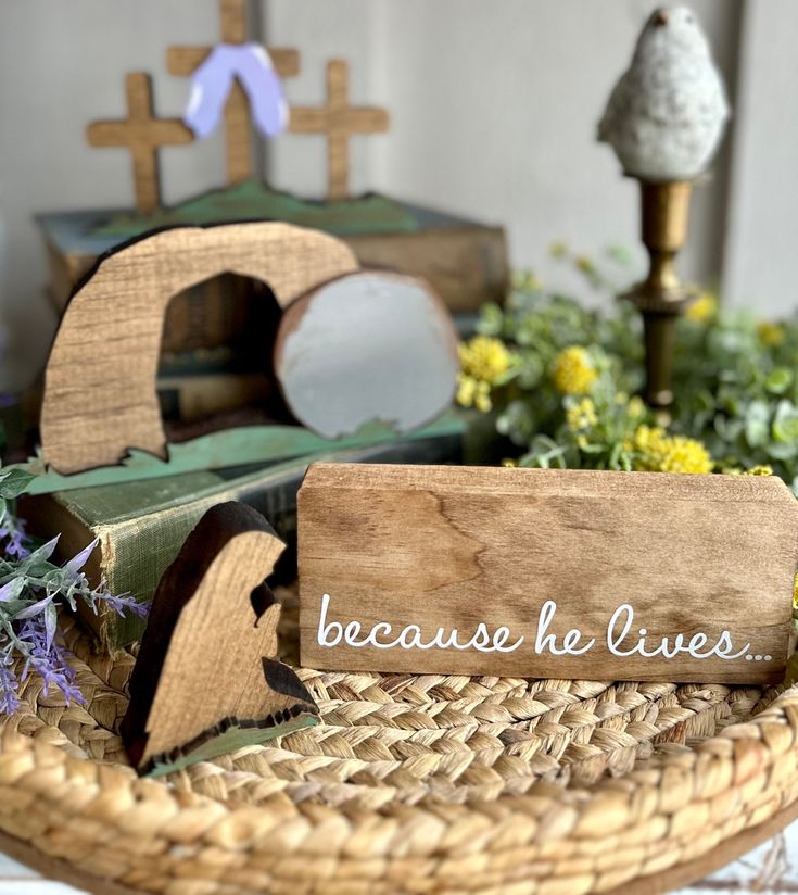 a wooden sign that says because he lives on it next to some flowers and candles