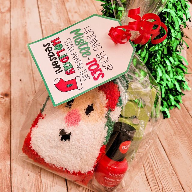 a christmas stocking sitting on top of a wooden table next to a wreath and tag