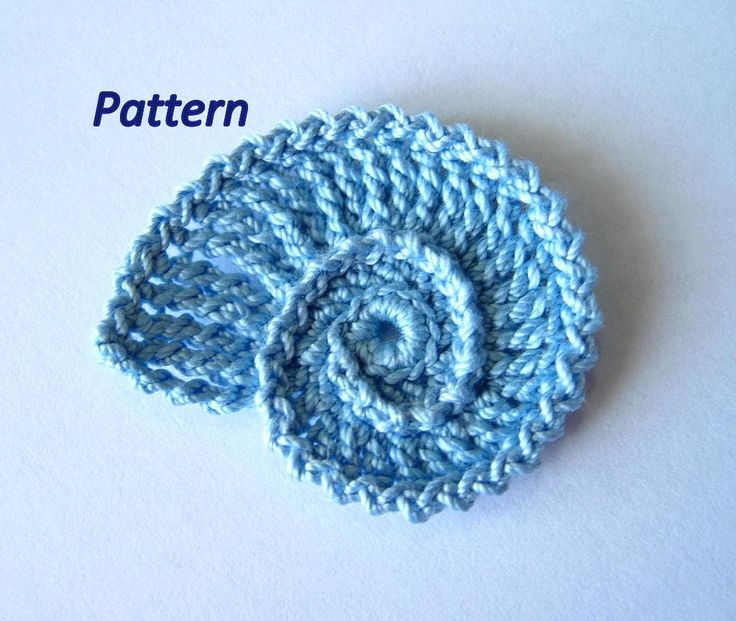 a crocheted blue flower on a white surface