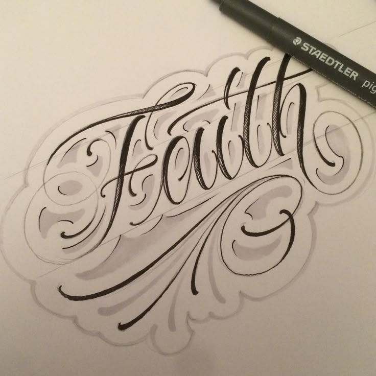 the word faith is written in cursive writing on paper with a black marker