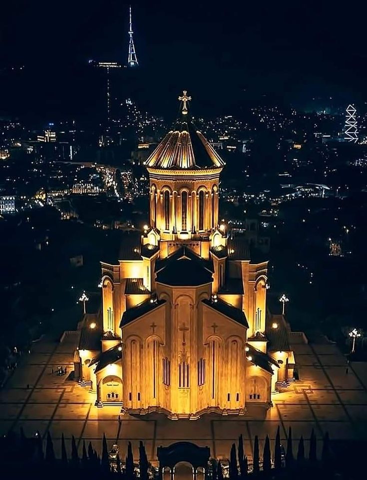 an aerial view of a church lit up at night