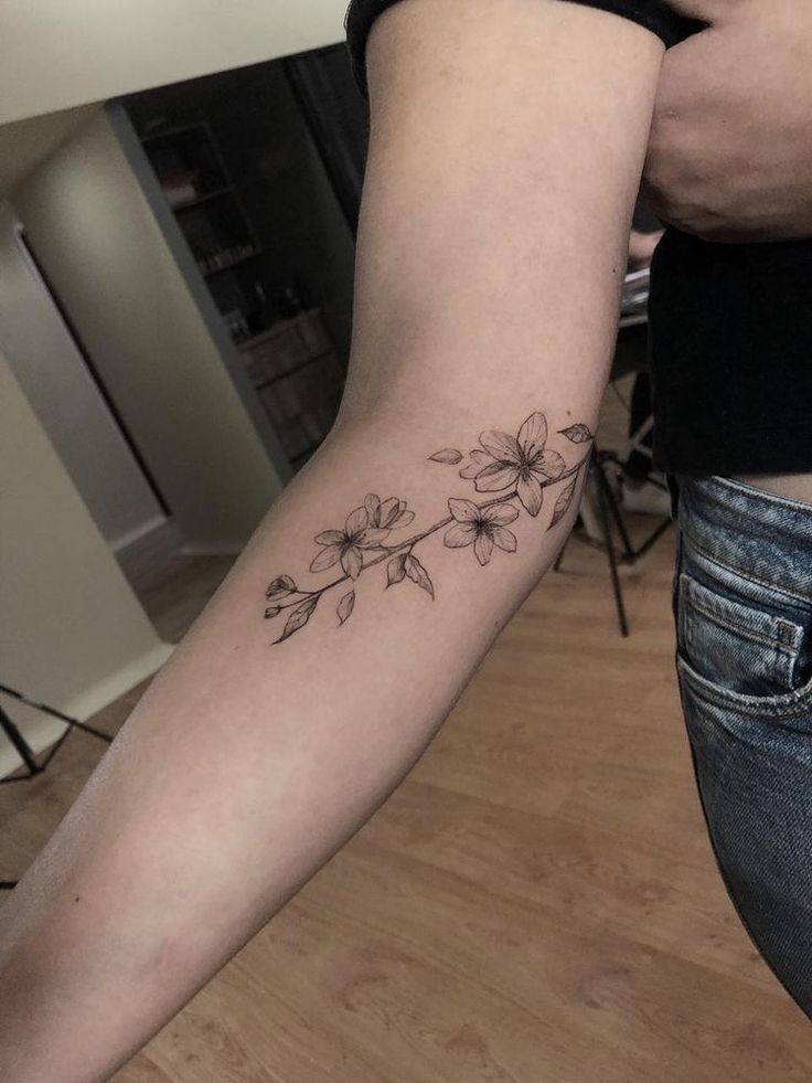 a woman's arm with flowers on it