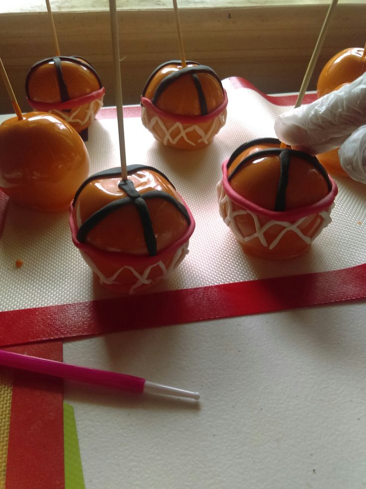 there are apples with sticks sticking out of them on the table next to some candy