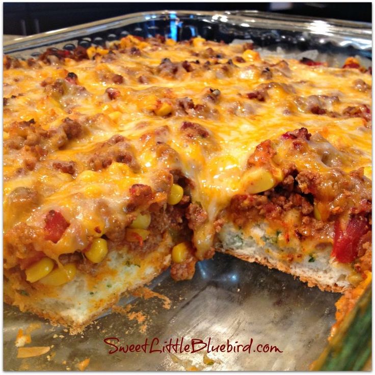 a cheesy casserole with meat and vegetables is cut in half to show the inside