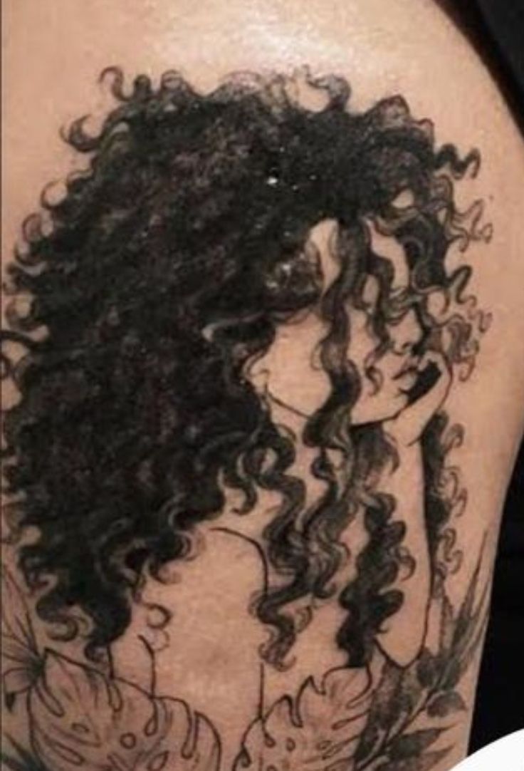 a woman with curly hair is shown on her thigh