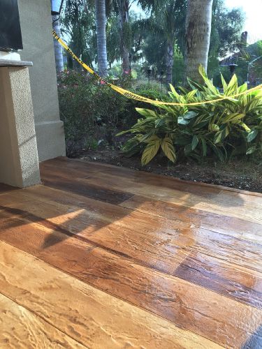 an outdoor kitchen with wood flooring next to trees