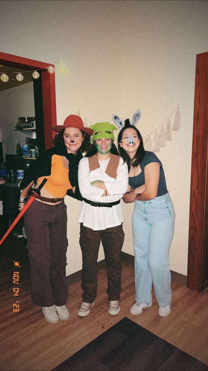 three young women standing next to each other in front of a mirror with bunny ears on