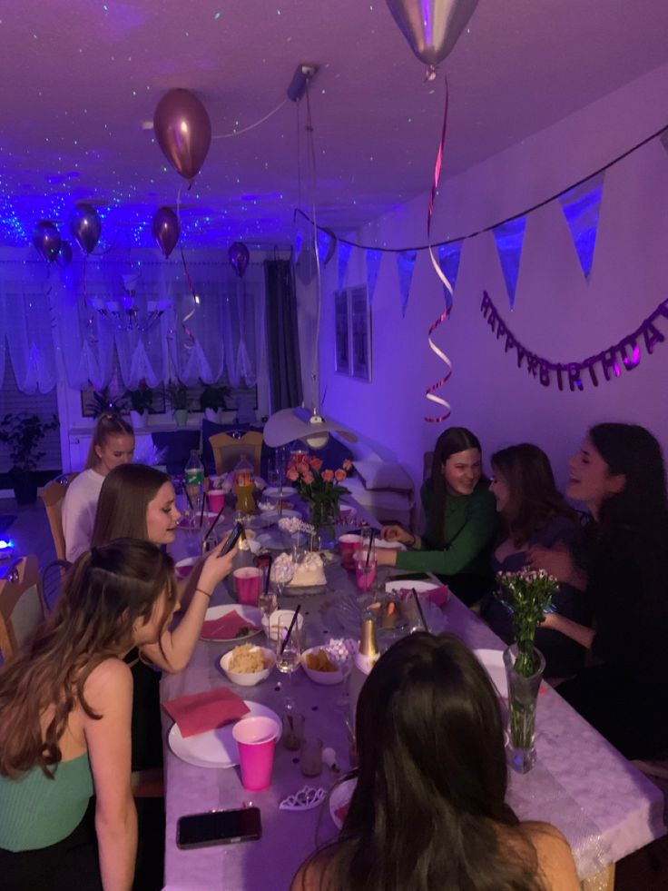 a group of people sitting around a table with food and drinks in front of them