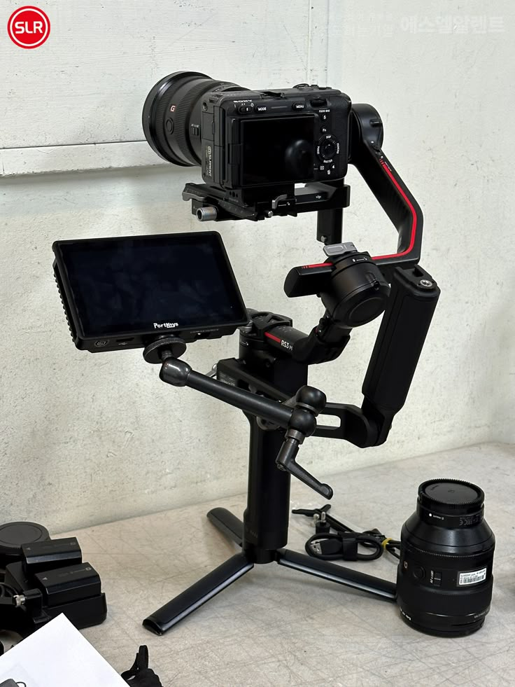 a tripod with a camera attached to it next to a laptop and other equipment