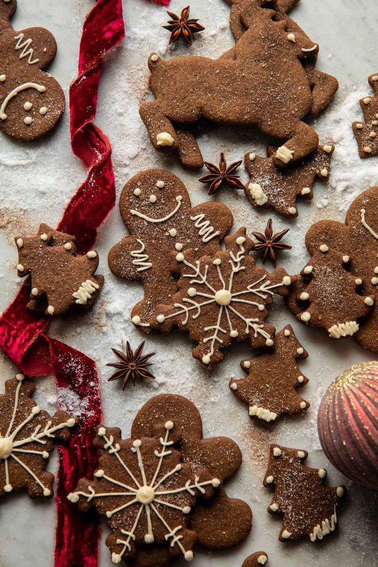 gingerbread cookies decorated with icing and sprinkles are on a table