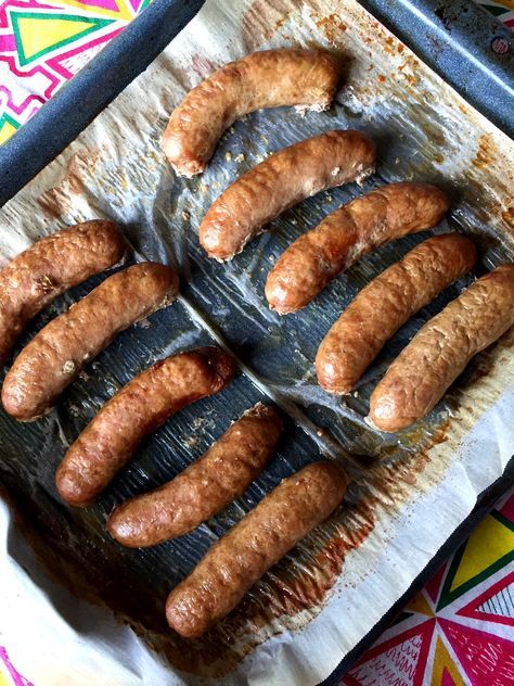 there are many sausages on the tray ready to be cooked in the oven,