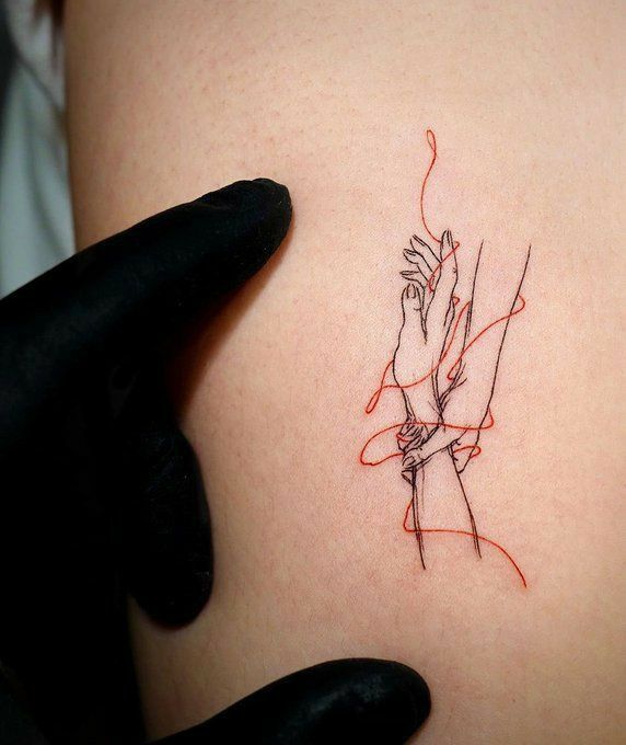 a woman's arm with a red line drawing on the back of her shoulder