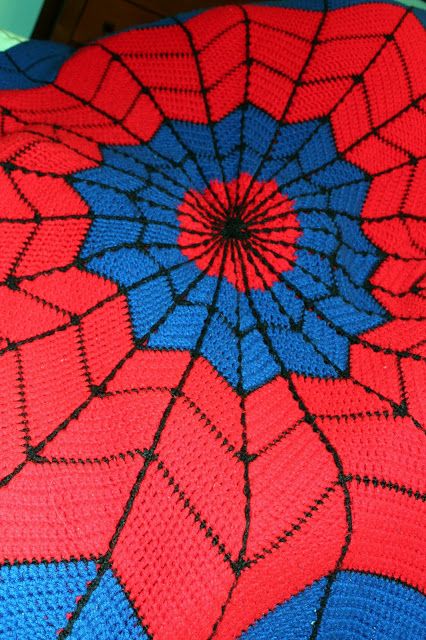 a crocheted spiderman afghan is shown in blue and red colors, with an intricate design on the top