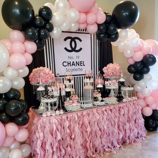 a chanel themed dessert table with black, white and pink balloons